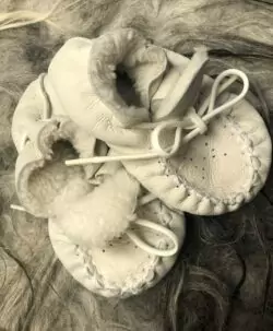 Nydelige tasser i saueskinn fra danske HUTTEliHUT. Passer supert i vogna så små tær holder seg varme. Disse er produsert av overskuddsmamteriell så foret kan ha litt ulike nyanser.