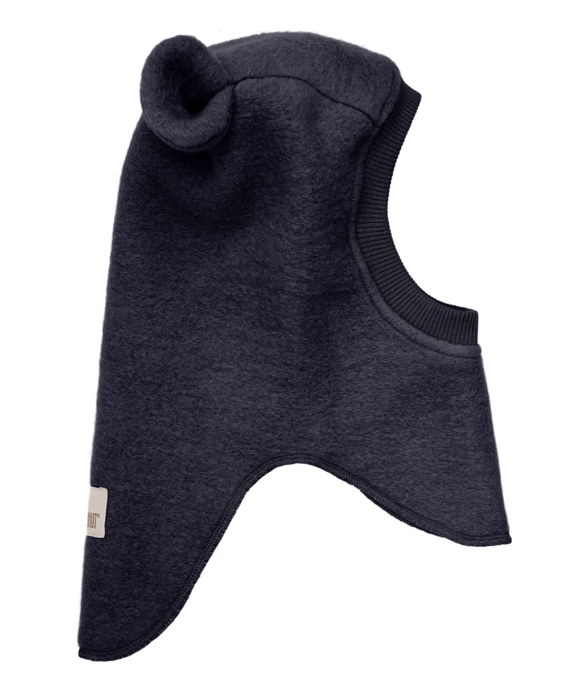 Supersøt og varm balacalva med små ører i tovet ull (80% ull og 20% polyester) fra HUTTEliHUT. Foret er laget av myk bomullsvelour som gjør den ekstra varm og vindtett på kalde dager. Ribbekanten rundt ansiktet er i bomull som gjør at den ikke klør. Vaskes fint på 30 grader ullprogram med vaskemiddel for ull/silke. Tørkes flatt.