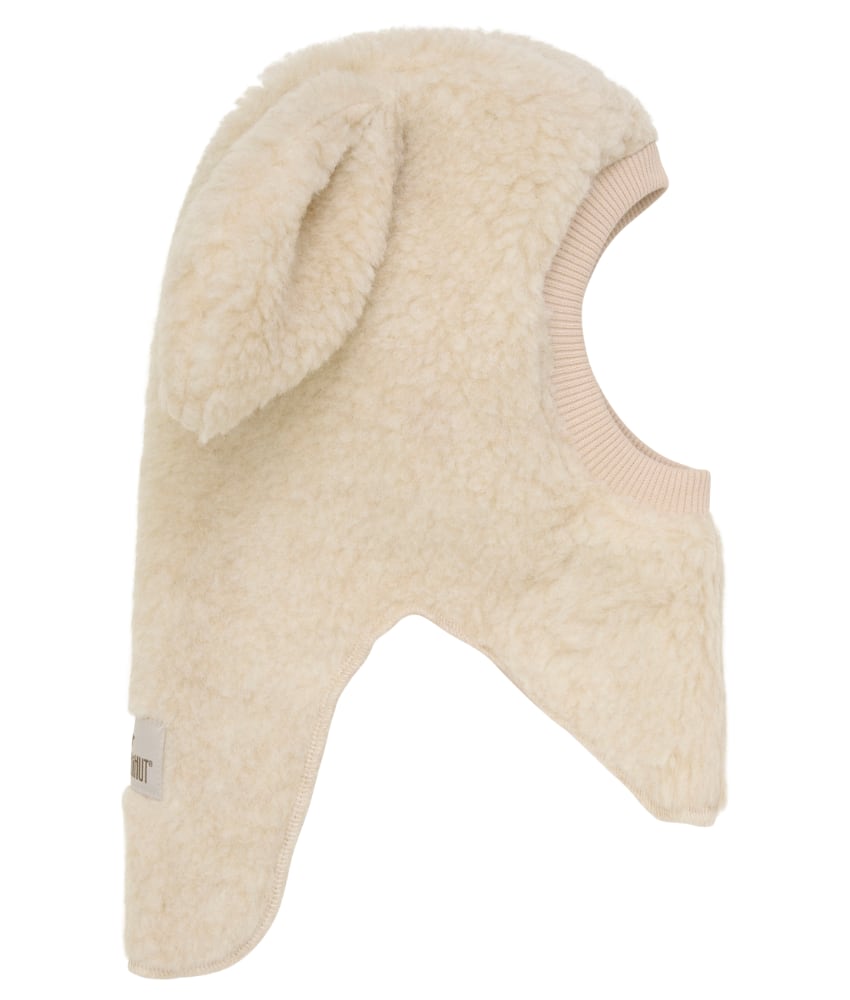 Supersøt og varm balaclava med søte ører i 100% merinoull teddy fra danske Huttelihut. Luen er foret med myk bomull som gjør den ekstra varm og vindtett på kalde dager. Ribbekanten rundt ansiktet er i bomull som gjør at den ikke klør. Vaskes fint på 30 grader ullprogram med vaskemiddel for ull/silke. Tørkes flatt.