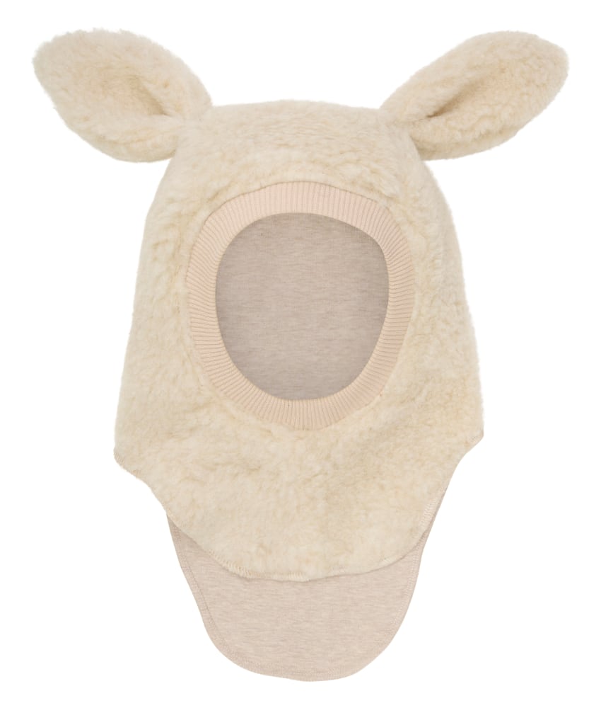 Supersøt og varm balaclava med søte ører i 100% merinoull teddy fra danske Huttelihut. Luen er foret med myk bomull som gjør den ekstra varm og vindtett på kalde dager. Ribbekanten rundt ansiktet er i bomull som gjør at den ikke klør. Vaskes fint på 30 grader ullprogram med vaskemiddel for ull/silke. Tørkes flatt.