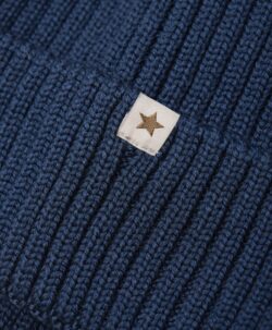 Nydelig HUTTEliHUT lue i ribbestrikket materiale. HUTTEliHUT-luen har en rund hodeform og en bred kant med brett. Strikket materiale er strikket i myk 100% merinoull. Sertifisert i henhold til OEKO-TEX® STANDARD 100. Dette produktet er kjent for sin holdbarhet hvis det behandles riktig: Vask det kun når det er nødvendig. Velg et skånsomt ullvaskemiddel. Ikke bruk tøymykner. Velg alltid skånsom ullvask i maskin, og vreng plagget. Bruk lav sentrifugering. Form plagget mens det er vått. Bruk lunkent vann for håndvask og unngå å vri det opp. Trykk forsiktig med et håndkle for å fjerne overflødig vann. Legg plagget flatt på et håndkle for å tørke – ikke legg det på en radiator eller i en tørketrommel.