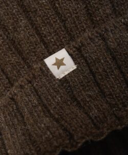 Nydelig strikket HUTTEliHUT lue med en stor og myk alpakkadusk på toppen av hodet. Luen er i en tykk, ribbestrikket kvalitet for kalde vinterdager. Innsiden av den ribbede bretten er strikket med et mykt bomullsgarn. HUTTEliHUT luen er laget av 80% merinoull og 20% polyamid. Dusken er et Fairtrade-produkt, laget med pels fra alpakkaer i det bolivianske høylandet. Hver dusk er unik og vil variere i farge og uttrykk. Ingen fargestoffer er involvert - bortsett fra naturens egen. Dusken er sydd for hånd og kan vaskes.  Hvis luen skal vaskes, bruk et skånsomt ullvaskemiddel. Ikke bruk tøymykner. Velg alltid skånsom ullvask i maskin, og vreng plagget på vrangen. Bruk et lavt sentrifugeringsprogram. Form plagget mens det er vått. Bruk lunkent vann til håndvask og unngå å vri det opp. Trykk forsiktig med et håndkle for å fjerne overflødig vann. Legg flatt på et håndkle for å tørke – ikke legg på en radiator eller i en tørketrommel.