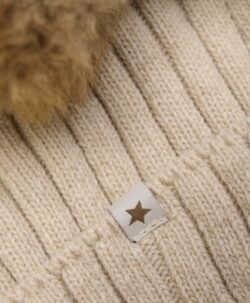 Nydelig strikket HUTTEliHUT lue med en stor og myk alpakkadusk på toppen av hodet. Luen er i en tykk, ribbestrikket kvalitet for kalde vinterdager. Innsiden av den ribbede bretten er strikket med et mykt bomullsgarn. HUTTEliHUT luen er laget av 80% merinoull og 20% polyamid. Dusken er et Fairtrade-produkt, laget med pels fra alpakkaer i det bolivianske høylandet. Hver dusk er unik og vil variere i farge og uttrykk. Ingen fargestoffer er involvert – bortsett fra naturens egen. Dusken er sydd for hånd og kan vaskes. Hvis luen skal vaskes, bruk et skånsomt ullvaskemiddel. Ikke bruk tøymykner. Velg alltid skånsom ullvask i maskin, og vreng plagget på vrangen. Bruk et lavt sentrifugeringsprogram. Form plagget mens det er vått. Bruk lunkent vann til håndvask og unngå å vri det opp. Trykk forsiktig med et håndkle for å fjerne overflødig vann. Legg flatt på et håndkle for å tørke – ikke legg på en radiator eller i en tørketrommel.