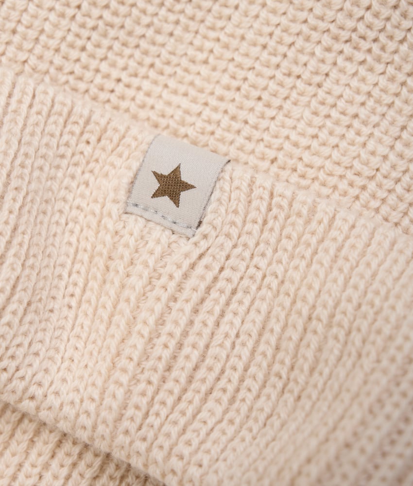 HUTTEliHUT lue i ribbestrikk, laget av 50% merinoull og 50% bomull. Luen har en rund form og en bred mansjett. Ved vask, velg et skånsomt ullvaskemiddel. Ikke bruk tøymykner. Velg alltid skånsom ullvask i maskin, og vreng plagget. Bruk et lavt sentrifugeringsprogram. Form plagget mens det er vått. For håndvask, bruk lunkent vann og unngå å vri det opp. Trykk forsiktig med et håndkle for å fjerne overflødig vann. Legg det flatt på et håndkle for å tørke – ikke legg det på en radiator eller i en tørketrommel.