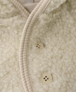 Nydelig jakke fra HUTTEliHUT med fine treknapper og sidelommer. Den har en fast hette med spiss form og en søt dusk, noe som gir jakken et veldig søtt utseende. Laget av 100% merinoull. Ved vask bruk et skånsomt ullvaskemiddel. Ikke bruk tøymykner. Velg alltid skånsom ullvask i maskin og vreng plagget. Bruk et lavt sentrifugeringsprogram. Form plagget når det er vått. For håndvask, bruk lunkent vann og unngå å vri det opp. Trykk forsiktig med et håndkle for å fjerne overflødig vann. Legg flatt på et håndkle for å tørke – ikke legg på en radiator eller i en tørketrommel.