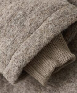 Vakker kåpe fra HUTTEliHUT med fine treknapper, lommer på sidene og en hette. Den tovede ulla er laget av 80% merinoull og 20% polyester. Kan vaskes i maskin på ullprogram 30 grader med vaskemiddel for ull/silke. Strekkes litt og tørkes flatt. Vårt tips er å ikke legge ull rett på varmekabler siden temperaturforskjell gjør at ullen krymper. 