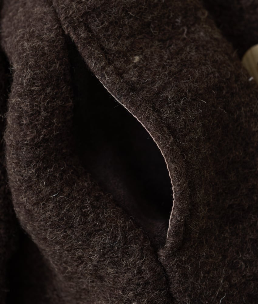 Vakker kåpe fra HUTTEliHUT med fine treknapper, lommer på sidene og en hette. Den tovede ulla er laget av 80% merinoull og 20% polyester. Kan vaskes i maskin på ullprogram 30 grader med vaskemiddel for ull/silke. Strekkes litt og tørkes flatt. Vårt tips er å ikke legge ull rett på varmekabler siden temperaturforskjell gjør at ullen krymper.