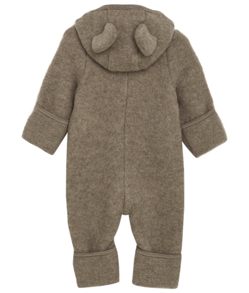 Smart og varm HUTTEliHUT dress i ullfleece. HUTTEliHUT dressen har en fast hette med en rund hodeform med små søte ører. Den har lange ermer og ben med praktiske folder opp til størrelse 80 for å holde små føtter og hender varme. Den har ribbekanter i alle åpninger. Den åpnes foran med en skjult glidelås med hakebeskyttelse. Laget av 100% merinoull. Dette produktet er kjent for sin holdbarhet hvis det behandles riktig: Vask det kun når det er nødvendig. Velg et skånsomt ullvaskemiddel. Ikke bruk tøymykner. Velg alltid skånsom ullvask i maskin, og vreng plagget på vrangen. Bruk et lavt sentrifugeringsprogram. Form plagget mens det er vått. Bruk lunkent vann til håndvask, og unngå å vri det opp. Trykk forsiktig med et håndkle for å fjerne overflødig vann. Legg flatt på et håndkle for å tørke – ikke legg på en radiator eller i en tørketrommel.