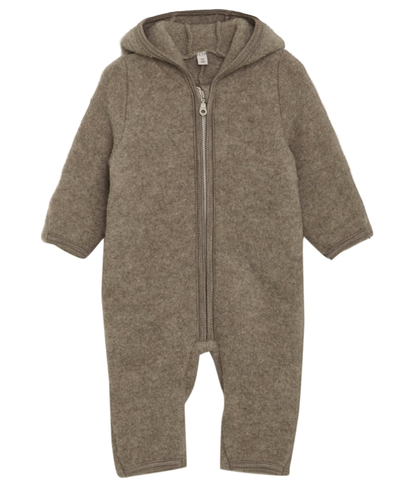 Smart og varm HUTTEliHUT dress i ullfleece. HUTTEliHUT dressen har en fast hette med en rund hodeform med små søte ører. Den har lange ermer og ben med praktiske folder opp til størrelse 80 for å holde små føtter og hender varme. Den har ribbekanter i alle åpninger. Den åpnes foran med en skjult glidelås med hakebeskyttelse. Laget av 100% merinoull. Dette produktet er kjent for sin holdbarhet hvis det behandles riktig: Vask det kun når det er nødvendig. Velg et skånsomt ullvaskemiddel. Ikke bruk tøymykner. Velg alltid skånsom ullvask i maskin, og vreng plagget på vrangen. Bruk et lavt sentrifugeringsprogram. Form plagget mens det er vått. Bruk lunkent vann til håndvask, og unngå å vri det opp. Trykk forsiktig med et håndkle for å fjerne overflødig vann. Legg flatt på et håndkle for å tørke – ikke legg på en radiator eller i en tørketrommel.