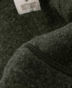 Smart og varm HUTTEliHUT dress i ullfleece. HUTTEliHUT dressen har en fast hette med en rund hodeform med små søte ører. Den har lange ermer og ben med praktiske folder opp til størrelse 80 for å holde små føtter og hender varme. Den har ribbekanter i alle åpninger. Den åpnes foran med en skjult glidelås med hakebeskyttelse. Laget av 100% merinoull.  Dette produktet er kjent for sin holdbarhet hvis det behandles riktig: Vask det kun når det er nødvendig. Velg et skånsomt ullvaskemiddel. Ikke bruk tøymykner. Velg alltid skånsom ullvask i maskin, og vreng plagget på vrangen. Bruk et lavt sentrifugeringsprogram. Form plagget mens det er vått. Bruk lunkent vann til håndvask, og unngå å vri det opp. Trykk forsiktig med et håndkle for å fjerne overflødig vann. Legg flatt på et håndkle for å tørke – ikke legg på en radiator eller i en tørketrommel.