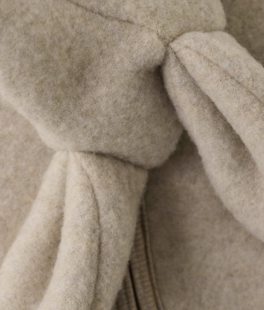 Smart og varm HUTTEliHUT alt-i-ett-dress laget av ullfleece. HUTTEliHUT-dressen har en fast hette med avrundet form og søte små kaninører på toppen. Barnevogndressen har lange ermer og ben med praktiske folder opptil størrelse 80 for å holde små føtter og hender varme. Alle åpninger har ribbekanter. Dressen åpnes foran med en skjult glidelås og hakebeskyttelse. Laget av 100% merinoull. Dette produktet er kjent for sin holdbarhet hvis det behandles riktig: Vask det kun når det er nødvendig. Velg et skånsomt ullvaskemiddel. Ikke bruk tøymykner. Velg alltid skånsom ullvask i maskin og vreng plagget på vrangen. Bruk et lavt sentrifugeringsprogram. Form plagget mens det er vått. Bruk lunkent vann til håndvask, og unngå å vri det opp. Trykk forsiktig med et håndkle for å fjerne overflødig vann. Legg flatt på et håndkle for å tørke – ikke legg på en radiator eller i en tørketrommel.