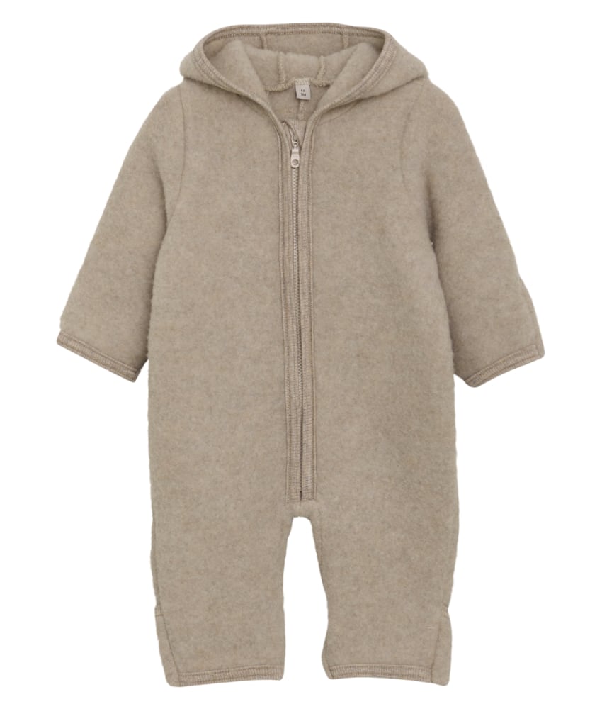 Smart og varm HUTTEliHUT alt-i-ett-dress laget av ullfleece. HUTTEliHUT-dressen har en fast hette med avrundet form og søte små kaninører på toppen. Barnevogndressen har lange ermer og ben med praktiske folder opptil størrelse 80 for å holde små føtter og hender varme. Alle åpninger har ribbekanter. Dressen åpnes foran med en skjult glidelås og hakebeskyttelse. Laget av 100% merinoull. Dette produktet er kjent for sin holdbarhet hvis det behandles riktig: Vask det kun når det er nødvendig. Velg et skånsomt ullvaskemiddel. Ikke bruk tøymykner. Velg alltid skånsom ullvask i maskin og vreng plagget på vrangen. Bruk et lavt sentrifugeringsprogram. Form plagget mens det er vått. Bruk lunkent vann til håndvask, og unngå å vri det opp. Trykk forsiktig med et håndkle for å fjerne overflødig vann. Legg flatt på et håndkle for å tørke – ikke legg på en radiator eller i en tørketrommel.