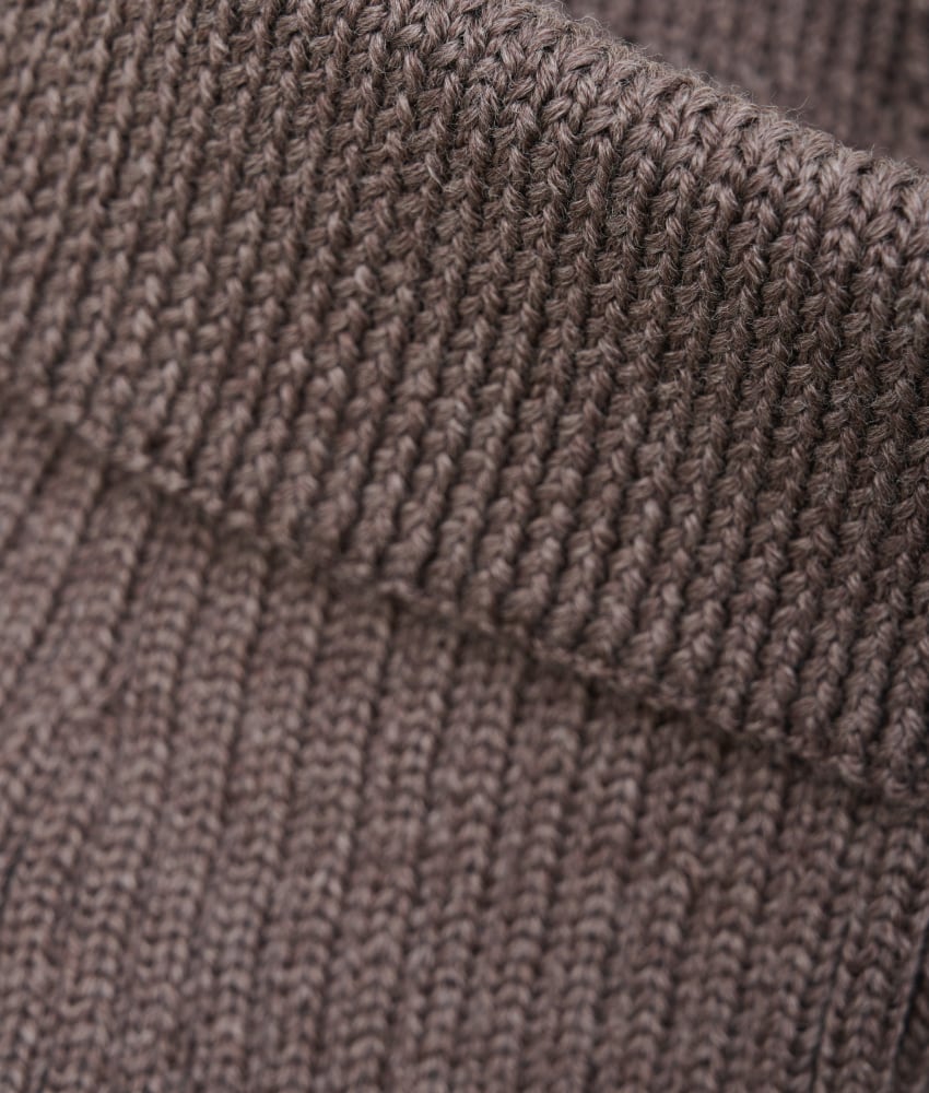 Vakker strikket halsvarmer fra HUTTEliHUT. Halsvarmeren har en bred ribbekant i halsen som går over i en V-hals, slik at barnet holder seg varmt. Laget av 100% merinoull. Dette produktet er kjent for sin holdbarhet hvis det behandles riktig: Vask det kun når det er nødvendig. Velg et skånsomt ullvaskemiddel. Ikke bruk tøymykner. Velg alltid skånsom ullvask i maskin og vreng plagget. Bruk lav sentrifugering. Form plagget mens det er vått. Bruk lunkent vann for håndvask og unngå å vri det opp. Trykk forsiktig med et håndkle for å fjerne overflødig vann. Legg plagget flatt på et håndkle for å tørke – ikke legg det på en radiator eller i en tørketrommel.