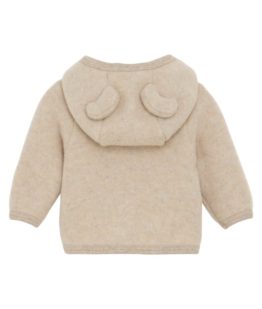 Nydelig HUTTEliHUT jakke i ullfleece. Jakken har en fast hette med søte bamseører. Den har lange ermer og smale myke ribbekanter i alle åpninger. Jakken åpnes foran med glidelås med hakebeskyttelse. Laget av 100% merinoull. Dette produktet er kjent for sin holdbarhet hvis det behandles riktig: Vask det kun når det er nødvendig. Velg et skånsomt ullvaskemiddel. Ikke bruk tøymykner. Velg alltid skånsom ullvask i maskin og vreng plagget på vrangen. Bruk et lavt sentrifugeringsprogram. Form plagget når det er vått. Bruk lunkent vann for håndvask og unngå å vri det opp. Trykk forsiktig med et håndkle for å fjerne overflødig vann. Legg flatt på et håndkle for å tørke – ikke legg på en radiator eller i en tørketrommel.