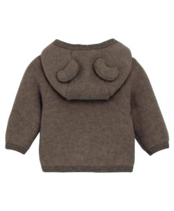 Nydelig HUTTEliHUT jakke i ullfleece. Jakken har en fast hette med søte bamseører. Den har lange ermer og smale myke ribbekanter i alle åpninger. Jakken åpnes foran med glidelås med hakebeskyttelse. Laget av 100% merinoull.  Dette produktet er kjent for sin holdbarhet hvis det behandles riktig: Vask det kun når det er nødvendig. Velg et skånsomt ullvaskemiddel. Ikke bruk tøymykner. Velg alltid skånsom ullvask i maskin og vreng plagget på vrangen. Bruk et lavt sentrifugeringsprogram. Form plagget når det er vått. Bruk lunkent vann for håndvask og unngå å vri det opp. Trykk forsiktig med et håndkle for å fjerne overflødig vann. Legg flatt på et håndkle for å tørke – ikke legg på en radiator eller i en tørketrommel.