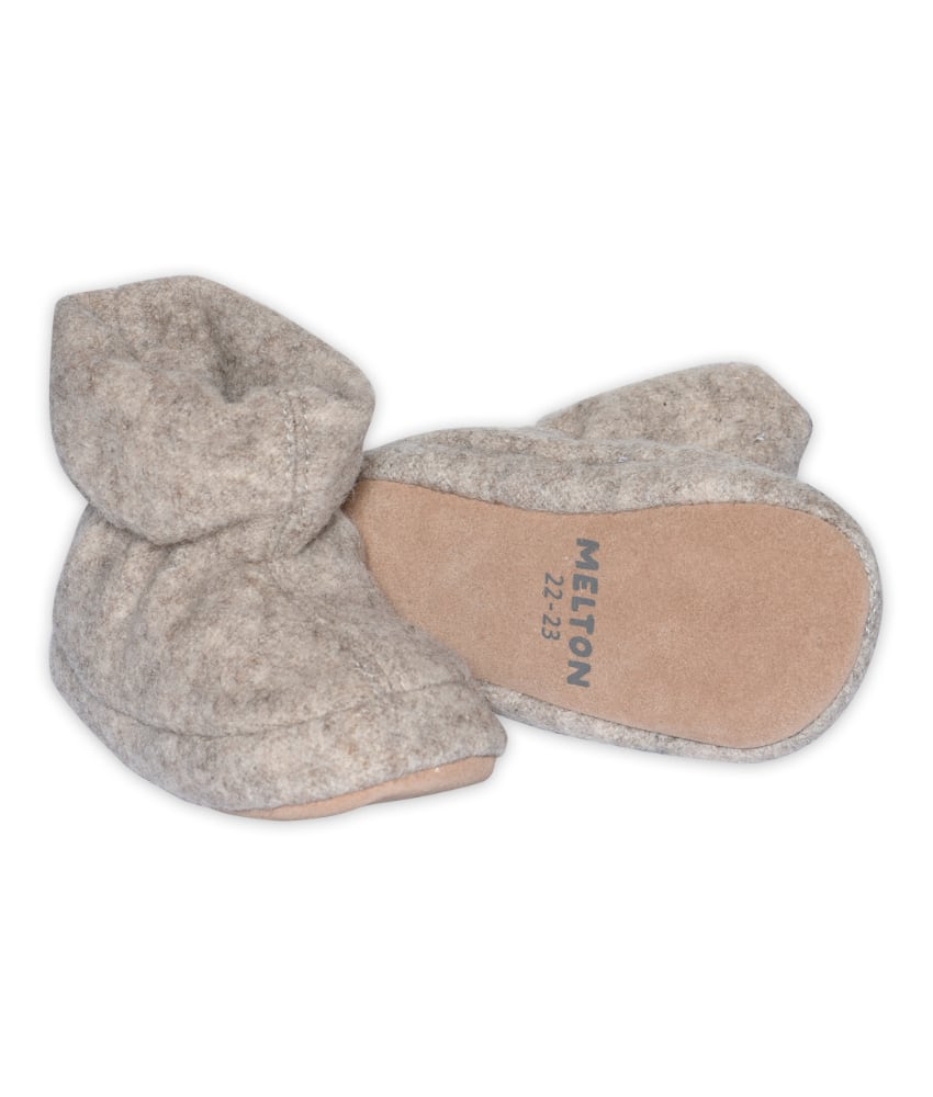 Myke, varme og praktiske ulltøfler fra danske Melton. Overdelen og sålen inni er laget av 100% myk tovet ull. Undersiden er laget av 100% semsket skinn som gjør at føttene får godt feste. Tøflene har en elastisk åpning som gjør det lett for barnet å ta de av og på seg. Disse kan brukes både til de minste i f.eks bilstol, bæresele eller til de litt litt større som tøfler i barnehagen.