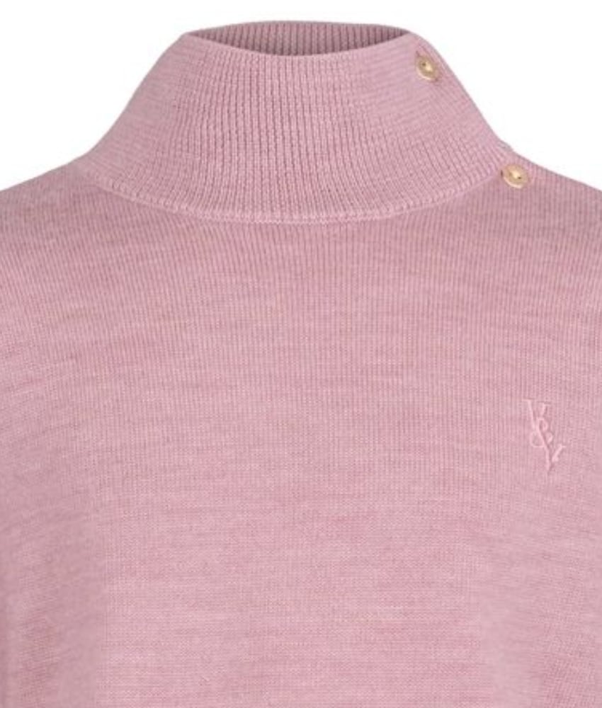 Rosa strikket ullgenser fra Vilje & Ve med høy hals og knappedetaljer, komplettert med en sjarmerende rysjekant nederst. Perfekt for en varm og stilig look og er superfin til Aspen strikket bukse.