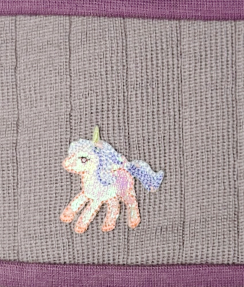 Pannebånd fra finske Kivat med søt enhjørning patch. Det er 100% ull på utsiden og innsiden er foret med bomull (97% økologisk bomull og 3% lycra) så det ikke klør. Det er sydd inn vindstopper for ved ørene. Kan vaskes i maskin på 30 grader ullprogram (vaskemiddel for ull/silke).