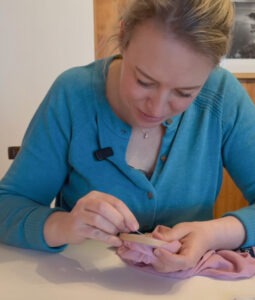 En dame er i gang med å reparere en strømpebukse.